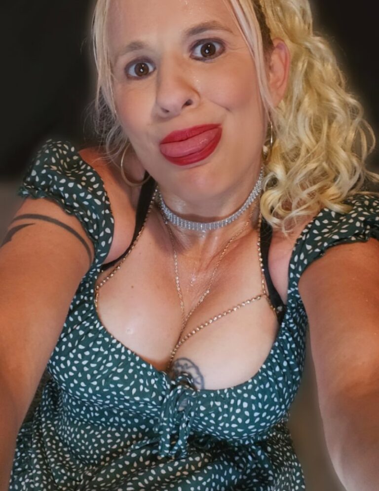 Close-up of Daisy Chain, the Pec Pop Queen, wearing a green polka dot dress and silver choker.