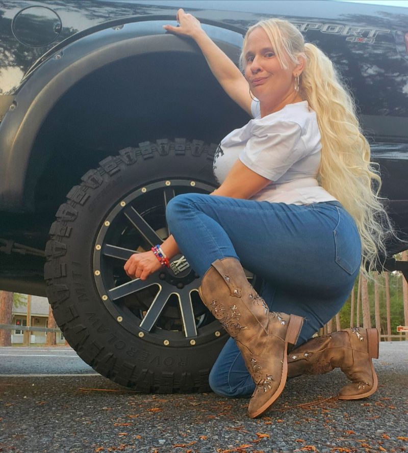 Queen Daisy Chain in Boots by a truck tire